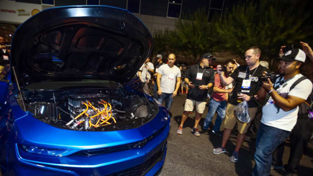  Show-goers get a closer look under the hood of the eCOPO Camaro Concept - an electrified vision for drag racing - Monday, October 29, 2018 at the SEMA Show in Las Vegas, Nevada. Developed by General Motors and built in partnership with the pioneering electric drag racing team Hancock and Lane Racing, the concept race car — based on the 2019 COPO Camaro — is entirely electric powered, driven by an electric motor providing the equivalent of more than 700 horsepower and 600 lb-ft of torque. Chevrolet estimates quarter-mile times in the 9-second range. Testing is ongoing. (Photo by Isaac Brekken for Chevrolet)