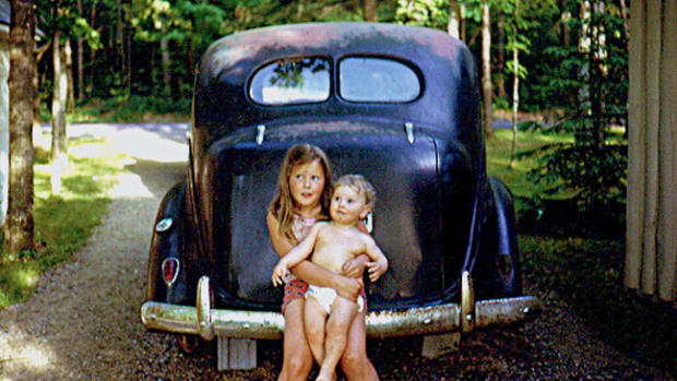  This picture of my sister and me was taken sometime in 1973 in the driveway of my family's cottage in the Northwoods of Wisconsin. Showing my pasty white baby physique in times before any thoughts of sunscreen.From what I was told the Plymouth's engine gave up the ghost in the early 60s and was parked in that spot until sometime in the early 90s. I gained many a bruise from that car seeing the tree swing hung just to the left of it beside the garage.