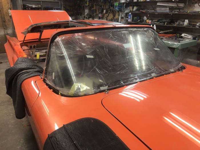 After a first attempt to get a windshield made (see www.tommaruskacars.us to learn about the fiasco), I found another fabricator in the good ole U S of A and had them make the glass. It turned out nice and is pictured below with the protective film still on. That will remain until the car is nearly complete.