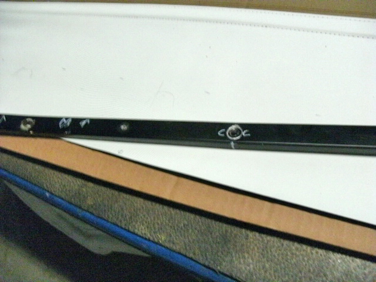 Directional arrows and lines marking the locations of holes and attachment points for the rear curtain and pad are visible on this view of the trim stick. This is a “before” image of the following image that appears at top right.