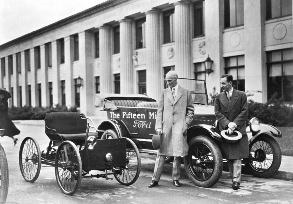 Henry and Edsel Ford stand beside the 15 millionth Ford, a 1927 Model T touring, while gazing upon the car that made it all happen — the Quadricycle, Ford’s first car.