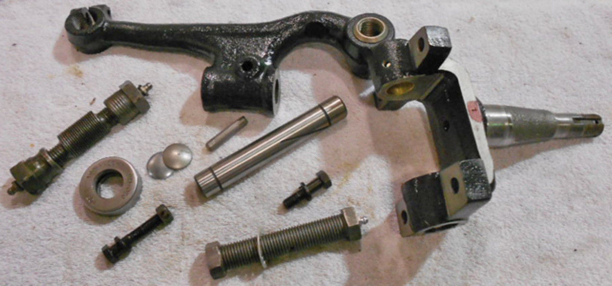 Figure 5: All the components are ready for assembly; the two big, threaded cylinders are the upper and lower support pins; the thrust bearing, end caps and locking pin are in line with the king pin in the center of the photo.