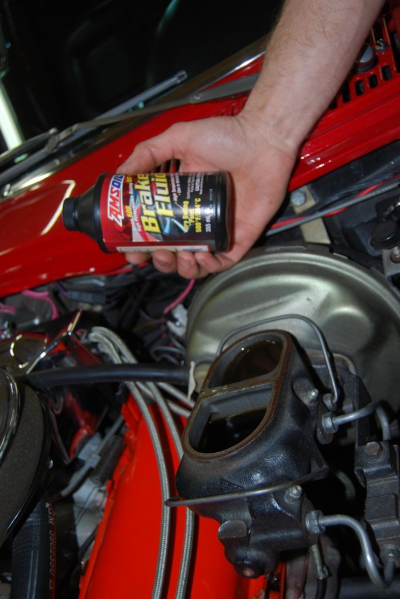 Take off the cover of the master cylinder to check the brake fluid level; top it off if it’s low.