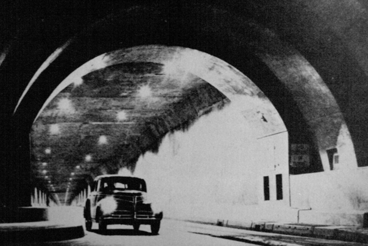 A 1941 Studebaker Commander emerges from the Pennsylvania Turnpike tunnel. Separate tubes opposing streams of traffic and graduated fluorescent lighting to adjust motorists' eyes to the interior were incorporated in subsequent improvement programs, - PA Turnpike Commisssion