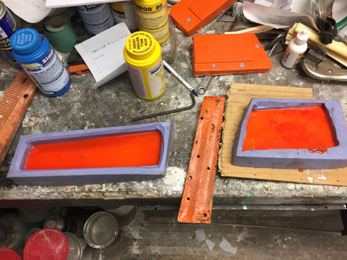  I mixed about half the liquid urethane needed and added coloring to get the shade of orange I was after and poured the molds a little less than half full. After it hardened enough so that the steel inserts wouldn’t sink, I laid them in place and then mixed and poured the other half of the orange urethane on top to fill the molds.
