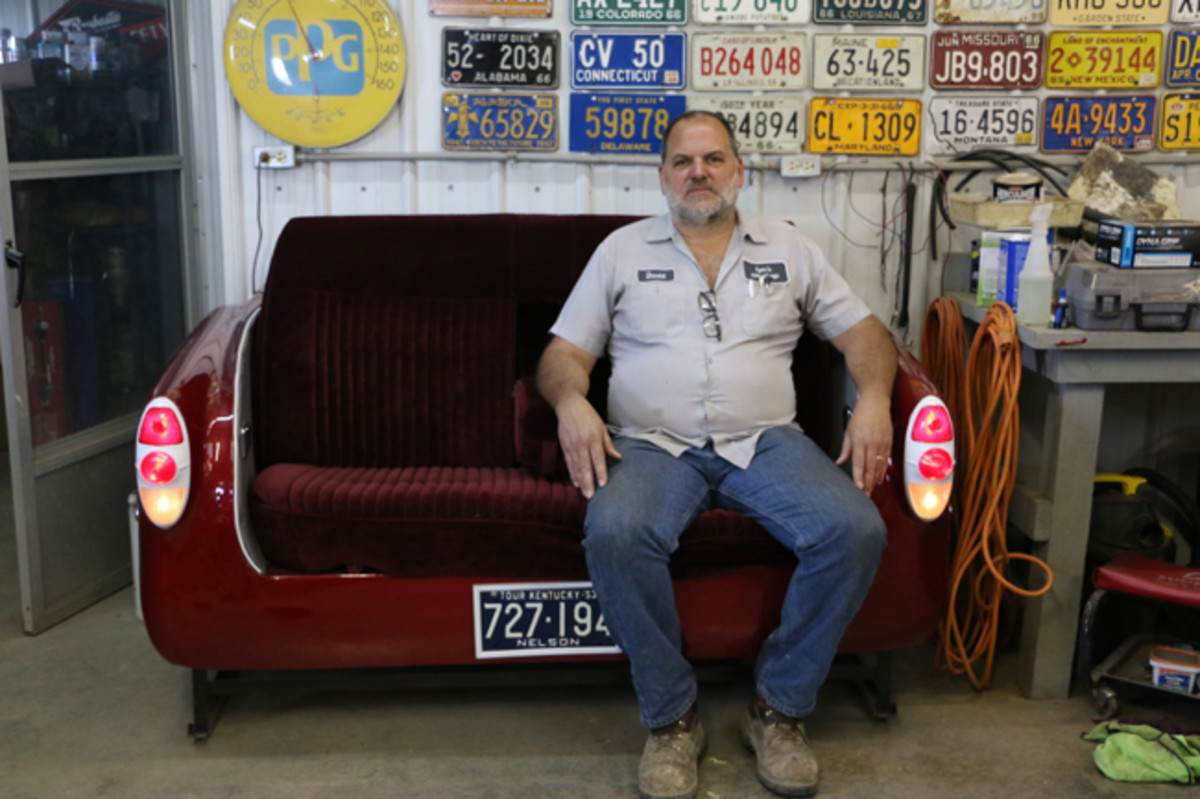  David Lyon, owner of Lyon’s Vintage Junkyard, takes a break on a couch he constructed from the rear of a 1953 Chevrolet. It has a center arm rest, working tail lamps and backup lamps and a 1953 Kentucky license plate. On the wall behind him is his license plate collection. He was born in 1966, and has a plate of that year from every state.