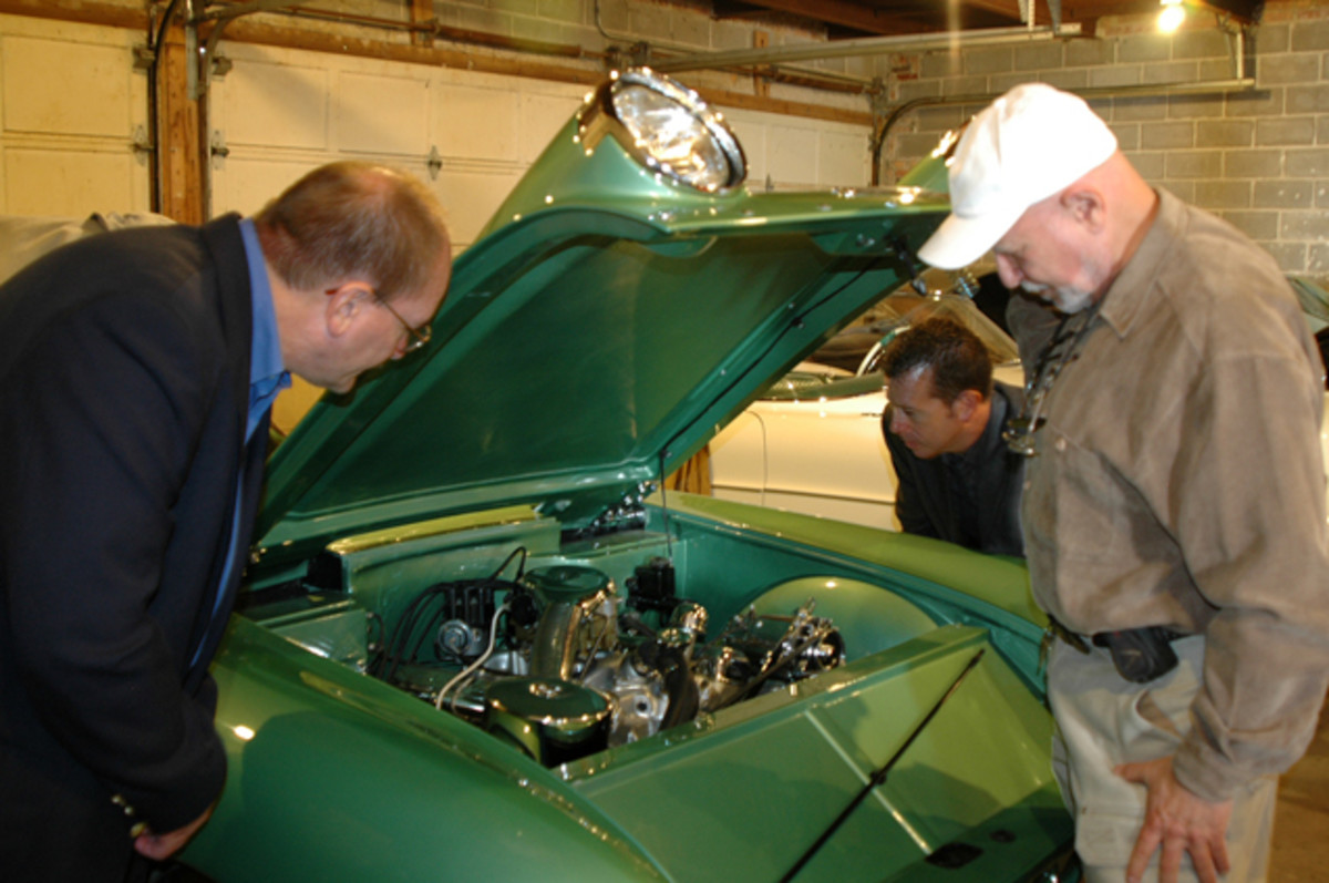  Thomas Roney (left) and Mark West (back) of the College for Creative Studies in Detroit study the engine compartment of the 1955 Chevrolet Biscayne concept car owned by Joe Bortz (right).