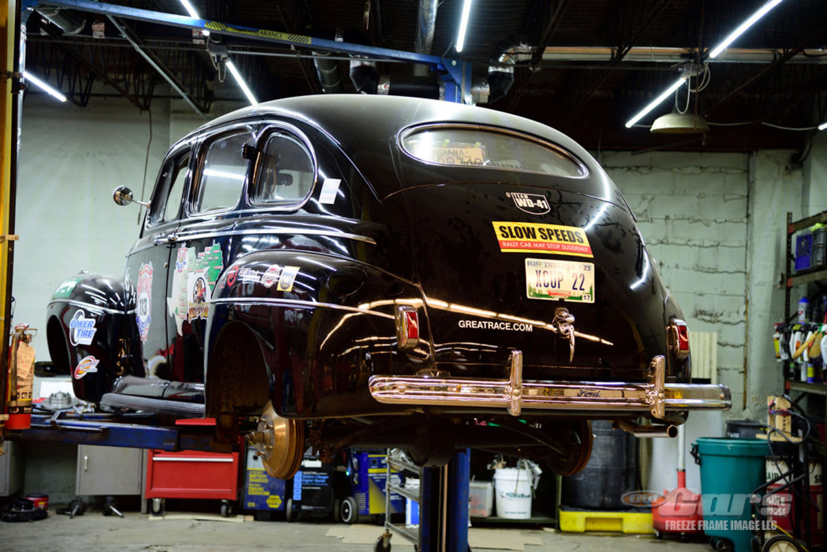 The 1941 Ford X-Cup Great Race car undergoes a front disc brake conversion by youth volunteers at the NATMUS Garage.