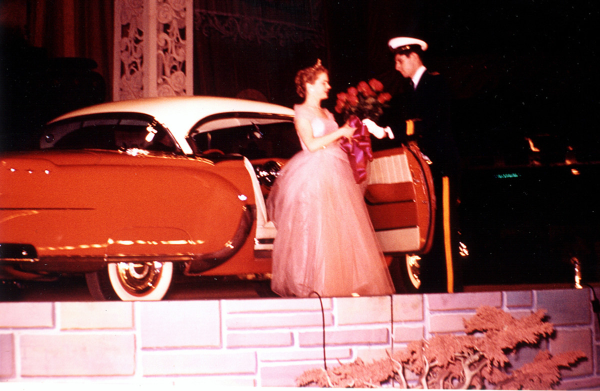 On stage during the “Wheels of Progress” revue, Miss Berwyn-Cicero (June) exits a 1954 Pontiac two-door hardtop and receives a dozen roses from Andy Frain usher Jack Gallagher. Each of the queens was presented roses on the final evening of the show.
