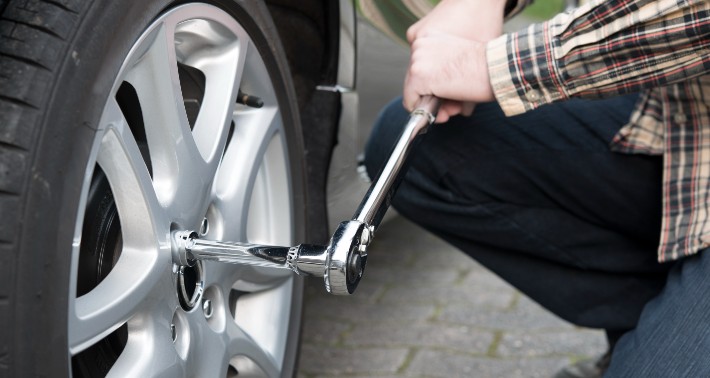 A man using a torque wrench to screw his tire in place