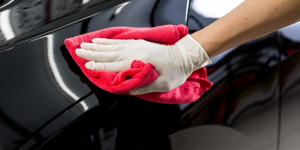 Closeup of hand cleaning black car