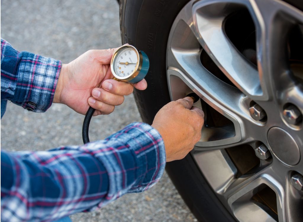 Man using a tire pressure gauge tool