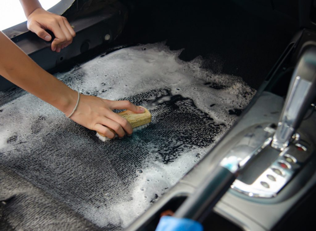 Person cleaning their car's carpet