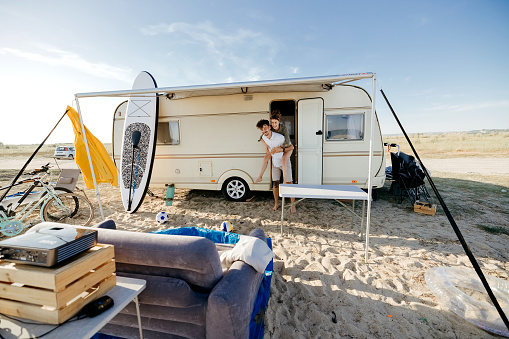 RV roof sealant Couple near an RV camper van parked near the sea
