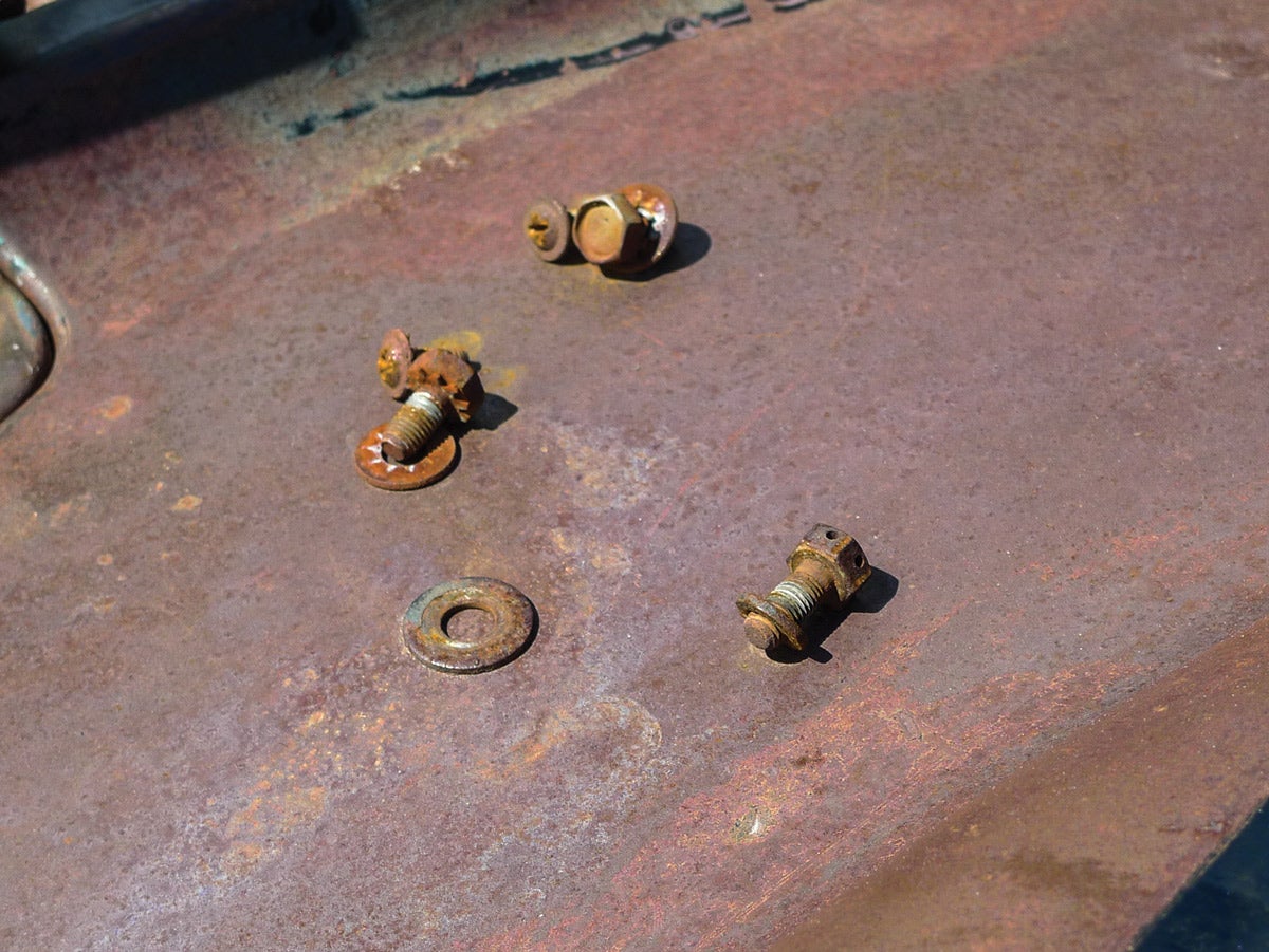 We can tell these parts have been separated before. Notice the mismatched fasteners? At least two of those remaining have rounded-off heads