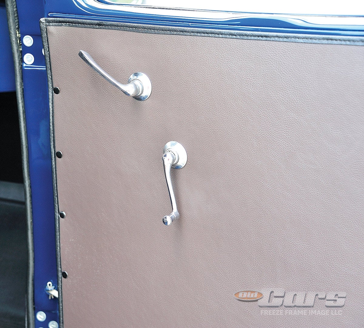 No arm rest, no courtesy lamps — just a door handle and window crank are found on the interior panel of each door.