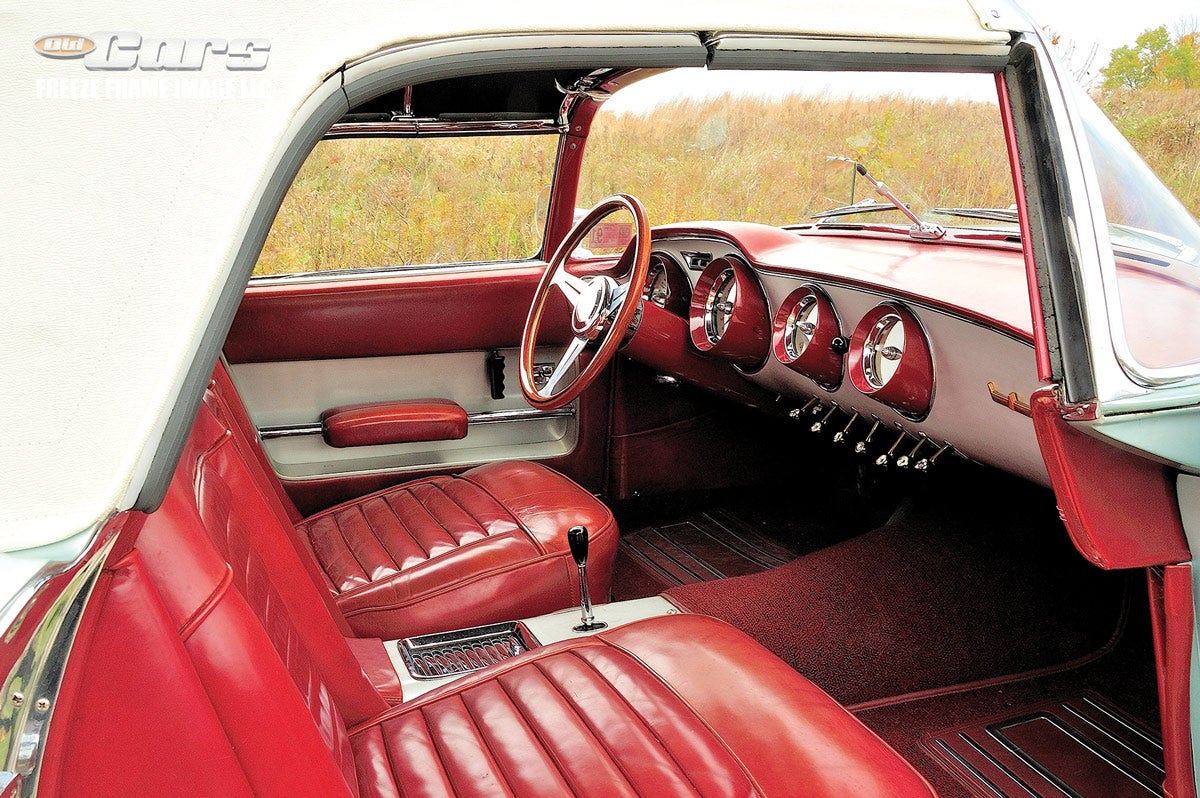 The cozy interior includes bucket seats for two and a small console, a novel feature in 1955. 
