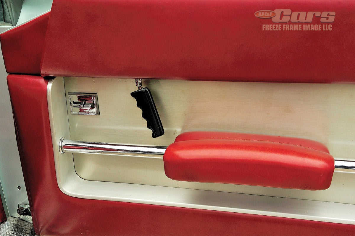 Recessed inner door panels feature a suspended arm rest and unusual grip for the door handle. Note the car is equipped with power windows, and he gauge pods and chrome levers beneath the dash.