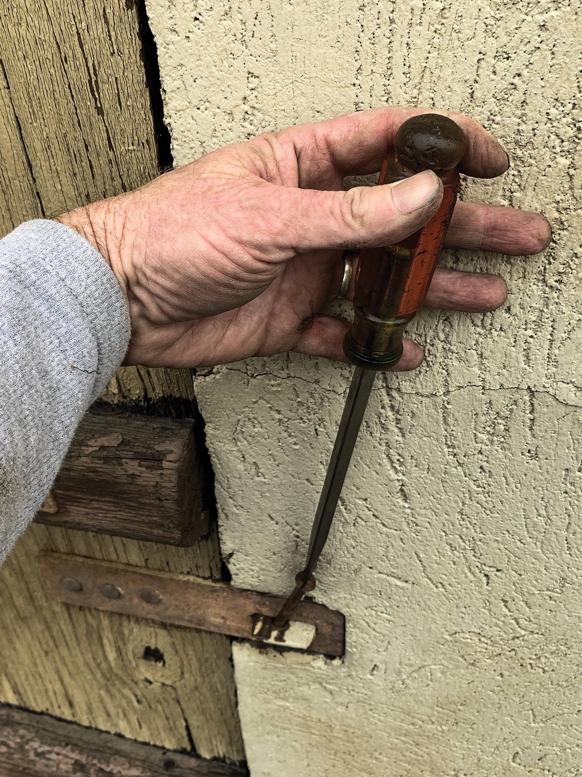Sure, this first part is reenactment, but this is exactly how the find unfolded. An ancient-era slotted screw was stuck and rusted to this farm-fabricated hasp